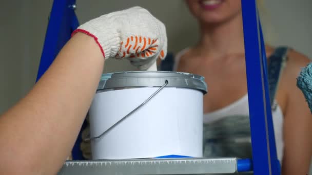 Dos trabajadoras que usan rodillo para pintar las paredes del apartamento o casa. Construcción, reparación y renovación . — Vídeo de stock