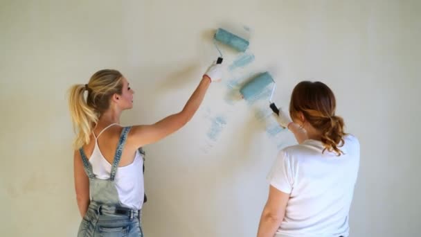 두 여자 근로자 아파트 또는 집에 있는 벽을 페인트 롤러를 사용 하 여. 건설, 수리 및 개조. — 비디오