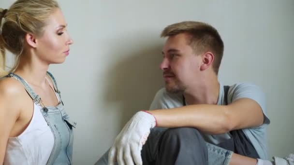 Young family couple worker using roller to paint the walls in the apartment or house. — Stock Video