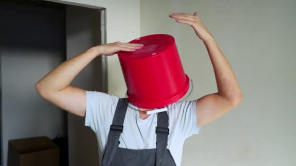 Worker in unifrom with red bucket on his head have fun and dancing — Stock Video