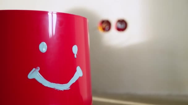 Červený kbelík s tváří v betonu v staveniště — Stock video