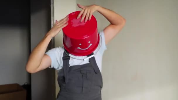 Работник в форме с красным ведром на голове веселитесь и танцуйте — стоковое видео