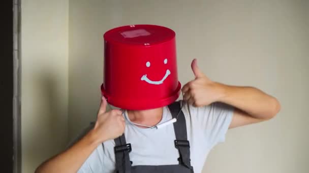 Работник в форме с красным ведром на голове веселитесь и танцуйте — стоковое видео