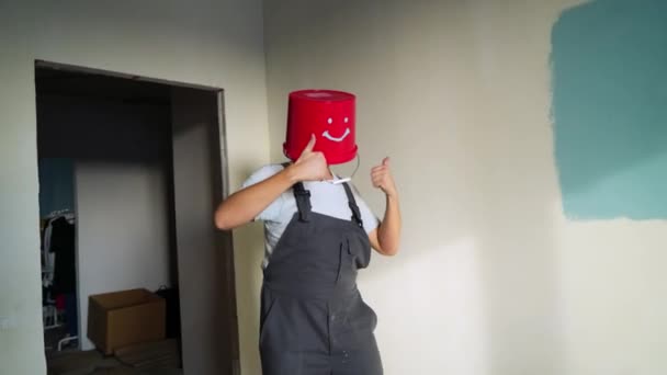 Worker in uniform with red bucket on his head have fun and dancing — Stock Video