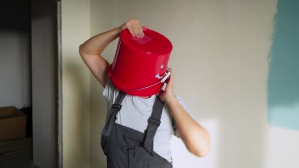 Trabajador en uniforme con cubo rojo en la cabeza divertirse y bailar — Vídeos de Stock