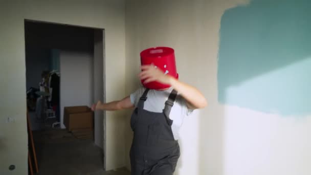 Trabajador en uniforme con cubo rojo en la cabeza divertirse y bailar — Vídeos de Stock