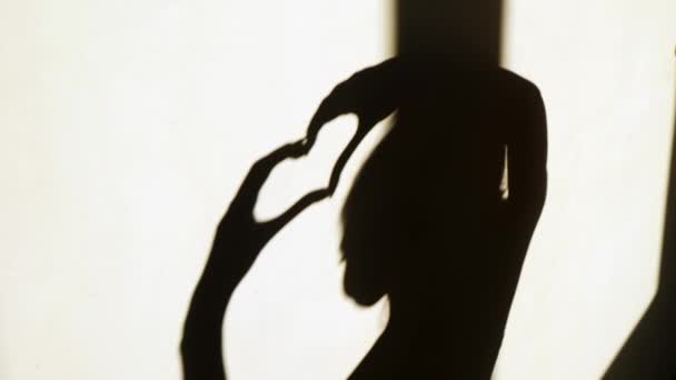 Femeie silueta arată inima cu mâinile ei — Videoclip de stoc