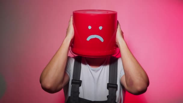 Worker in uniform with red bucket on his head sad — Stock Video