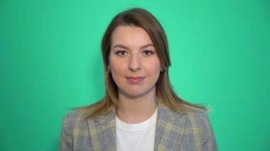 Sessizlik, sessizlik sessizlik işaret, yeşil arka plan üzerinde duran gösteren ağzında onun işaret parmağı tutan genç kadın portresi kadar yakın lütfen