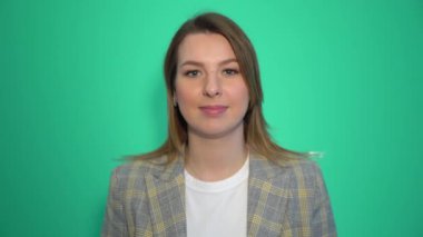Gülümseyen kadın hava öpücük kameraya yeşil arka plan üzerinde gönderir