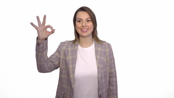 Boldog szőke nő mutatja ok alá, és nézte a kamerát, fehér háttér — Stock videók
