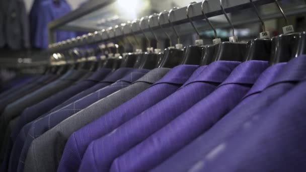 Row of men suit jackets on hangers — Stock Video