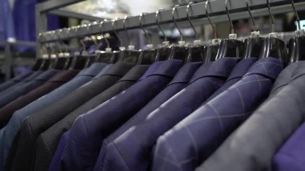 Fila de hombres traje chaquetas en perchas — Vídeos de Stock