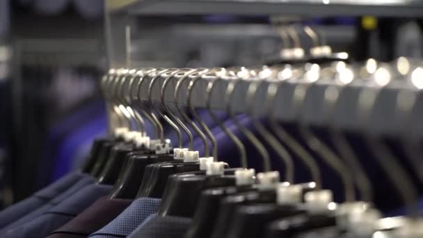 Row of men suit jackets on hangers — Stock Video