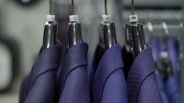 Alışveriş ve moda konsepti-genç adam seçimi ve alışveriş merkezi veya giyim mağazasında ceket çalışıyor