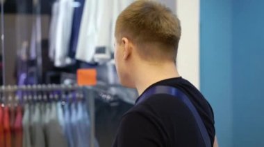 Genç çekici adam Dükkanı penceresine mens ile takım elbise alışveriş merkezinde bakarak