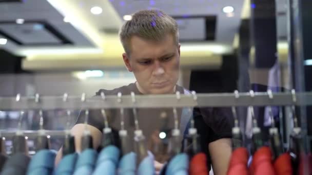 Jovem homem atraente olhando para vitrine com homens ternos no shopping — Vídeo de Stock