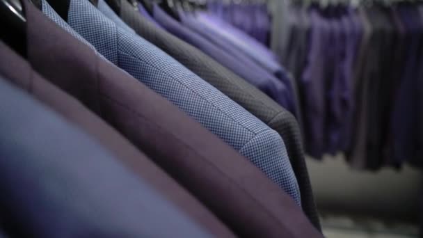 Fila de hombres traje chaquetas en perchas — Vídeos de Stock