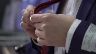 Alışveriş ve moda konsepti-genç adam seçimi ve alışveriş merkezi veya giyim mağazasında ceket çalışıyor