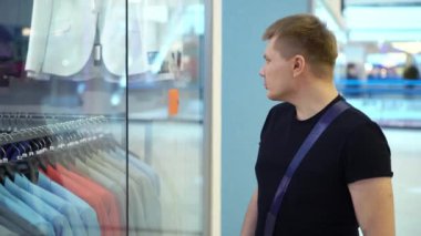 Genç çekici adam Dükkanı penceresine mens ile takım elbise alışveriş merkezinde bakarak