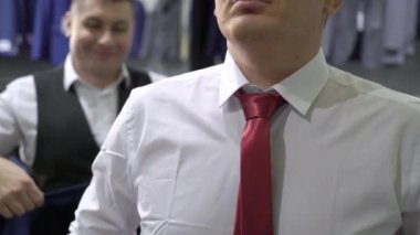 Alışveriş ve moda konsepti-genç adam seçimi ve alışveriş merkezi veya giyim mağazasında ceket çalışıyor