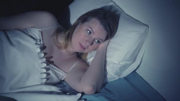 Mujer con insomnio acostada en la cama con los ojos abiertos — Vídeos de Stock