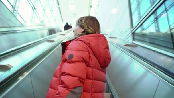 Giovane donna con una valigia a piedi alla scala mobile — Video Stock