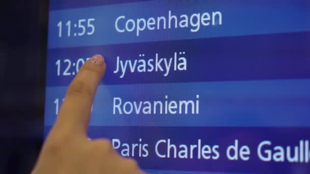 Frau blickt auf Informationstafel am Flughafen — Stockvideo