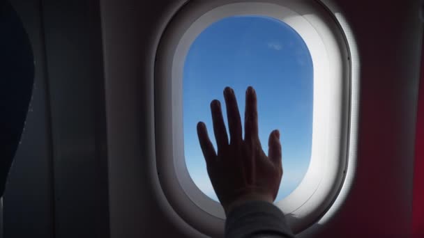 Silueta ženy ruka nad oknem letadla. Mraky a nebe, jak jsou vidět skrz okno letadla, letecký letoun — Stock video