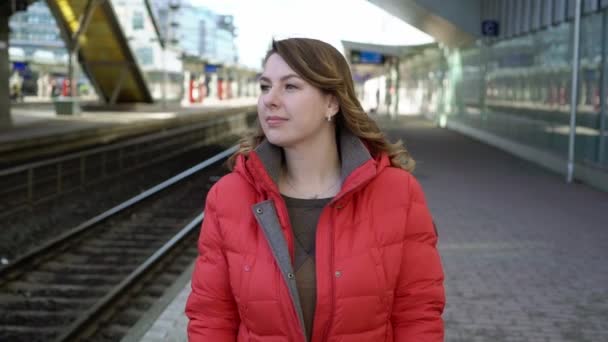Молодая женщина идет на станцию платформы, ожидая свой поезд — стоковое видео