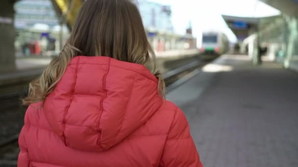 En ung kvinne som venter på toget. – stockvideo
