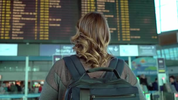 Mujer mirando tablero de información en el aeropuerto — Vídeo de stock