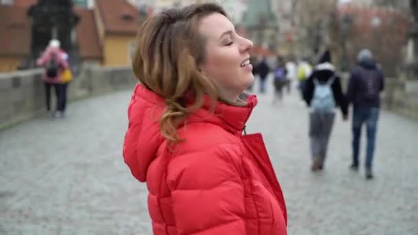 Девушка, идущая по мосту в европейском городе — стоковое видео