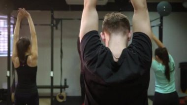 Genç insanlar bir çapraz eğitim spor salonunda kullanarak kollarını dışarı çalışma