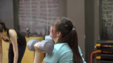 Genç insanlar bir çapraz eğitim spor salonunda kullanarak kollarını dışarı çalışma