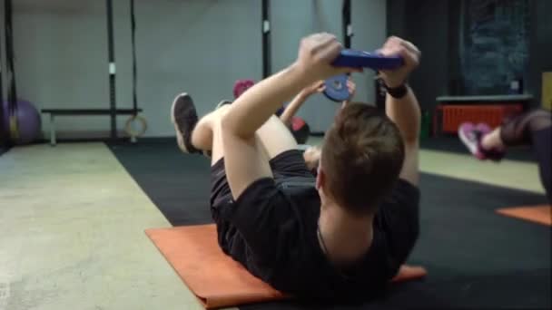 Group of young people working out their arms using in a cross-training gym — Stock Video