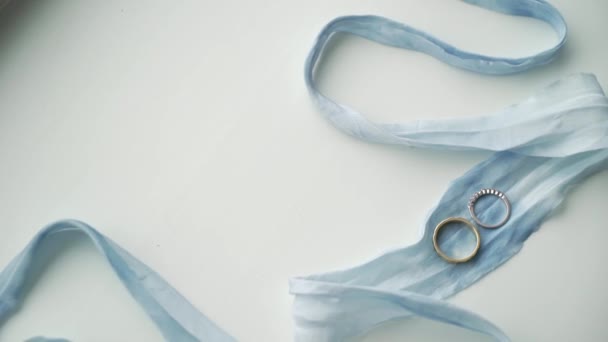 Dos anillos de boda en cinta azul — Vídeo de stock