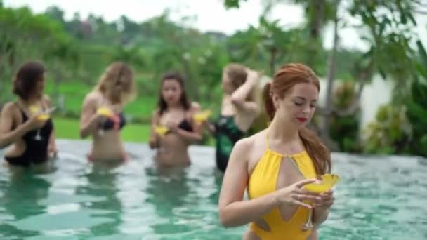 Přítelkyně v bazénu. Strana v letních prázdnin. Připijte si dívky s alkoholickými koktejly — Stock video