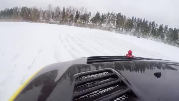 Voiture conduit par piste glacée sur le lac enneigé en hiver. Course de voitures de sport sur piste de course de neige en hiver. Conduire une voiture de course sur une route enneigée . — Video