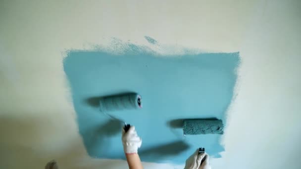 Két nő a munkavállalók görgő segítségével festeni a falakat, a lakás vagy ház. Építési, javítási és felújítási. — Stock videók