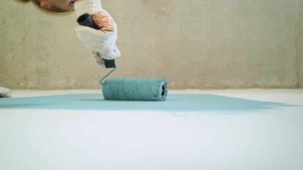 Kvinna arbetaren använda roller i en hink för att måla väggarna i lägenheten eller huset. Konstruktion, reparation och renovering. — Stockvideo