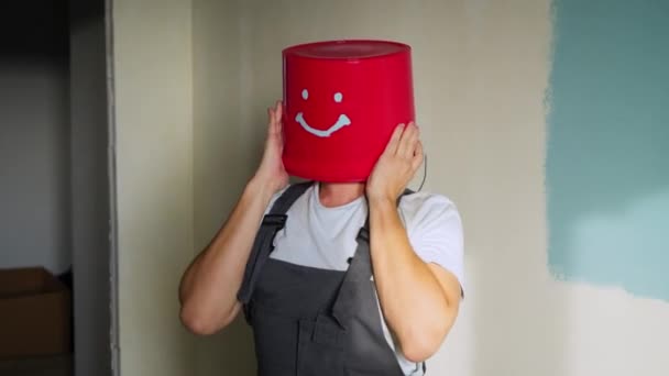 Trabajador en uniforme con cubo rojo en la cabeza divertirse y bailar — Vídeo de stock