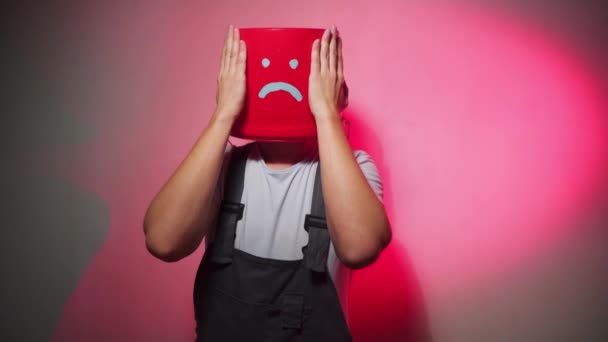 Munkavállaló egyenruhában, fején szomorú piros vödör — Stock videók