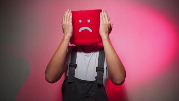 Εργαζόμενος σε ομοιόμορφο με κόκκινο κουβά στο κεφάλι του λυπημένος — Αρχείο Βίντεο