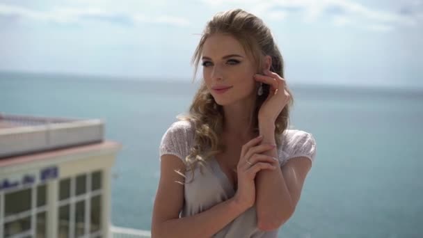 Giovane donna bionda in lingerie in posa sulla terrazza con vista mare — Video Stock