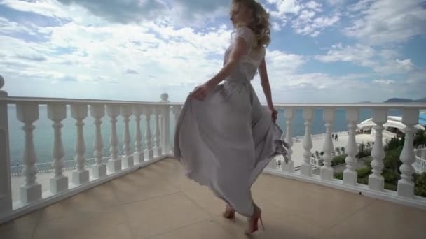 Mujer rubia joven en lencería posando en la terraza con vista al mar — Vídeos de Stock