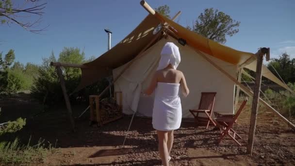 Young woman in towel near tent — Stockvideo