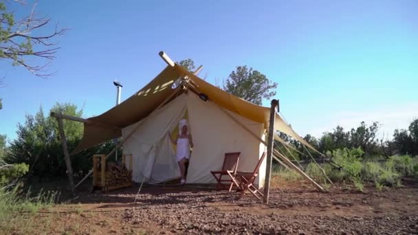 Ung kvinne i håndkle ved teltet – stockvideo