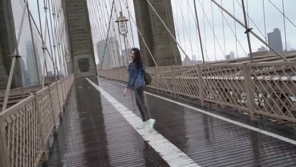 Ung kvinna går vid Brooklyn Bridge — Stockvideo