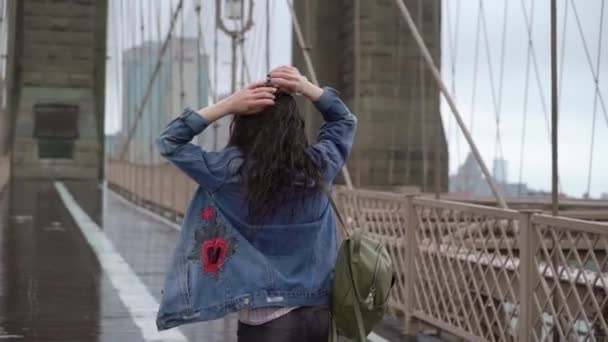 Young woman walking at Brooklyn bridge — 비디오